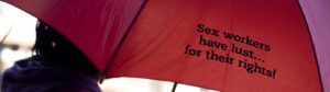 sex worker carrying red umbrella that reads 